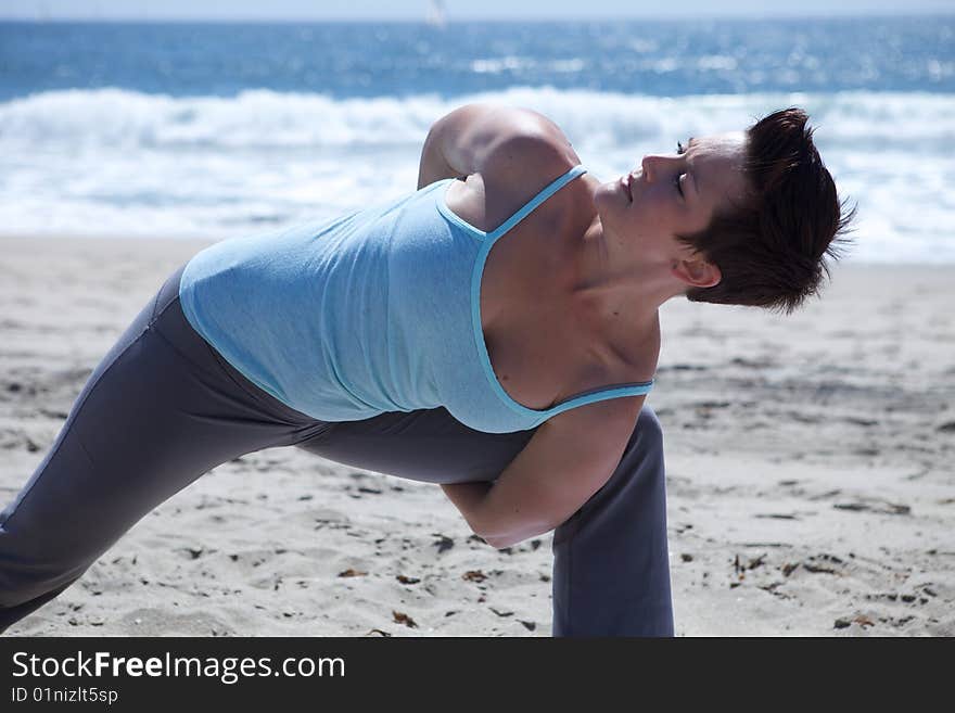 Woman Practicing Yogo at the Beach