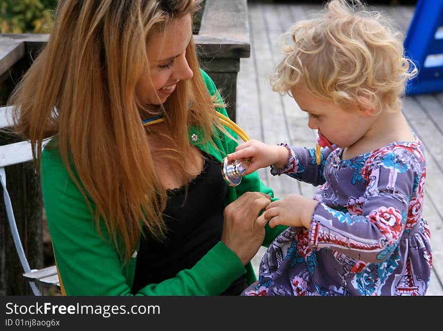 Mother holding her daughter checking her heartbeat. Mother holding her daughter checking her heartbeat