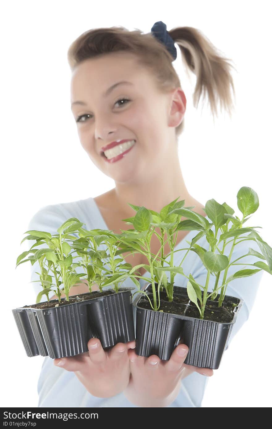 Smiling girl holding young plants