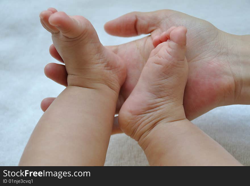 Hands and feet touch between chinese mother and baby show family and love. Hands and feet touch between chinese mother and baby show family and love.