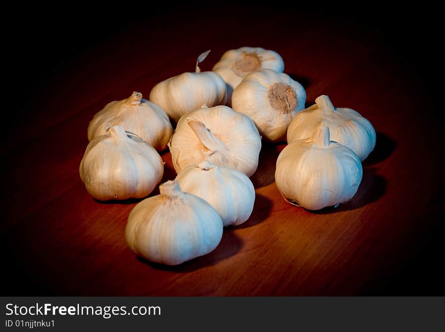 A small batch of garlic bulbs on a dark table