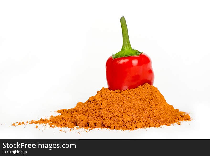 A pod of red hot pepper put  into  ground  pepper on a white background