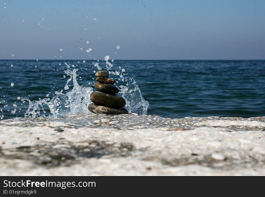 Splashing water and pile of stones on the beach. Splashing water and pile of stones on the beach