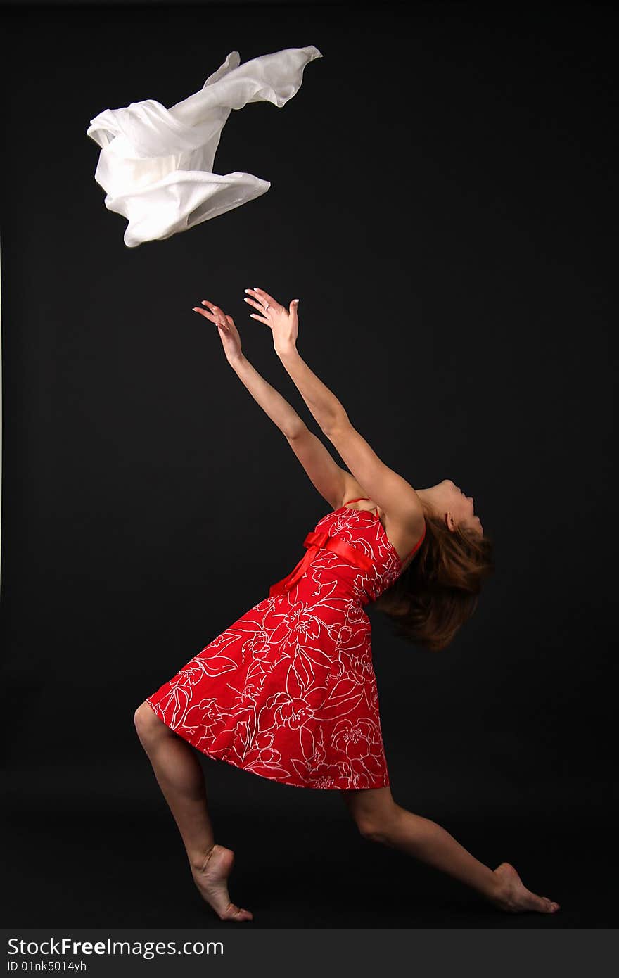 Elegant young flexible woman in red-white outfit with white scarf