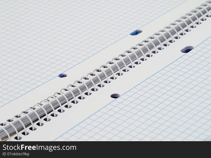 Spiral notebook with blue grid. Selective focus