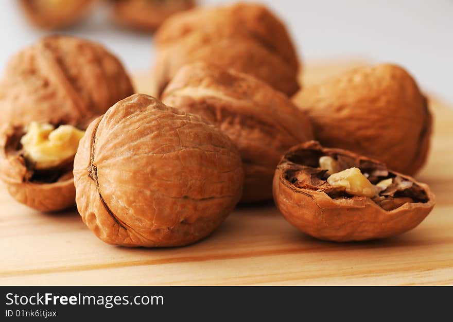 Cracked and whole walnuts on wooden table