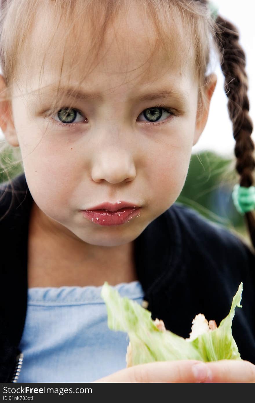 Little girl eats a sandwich