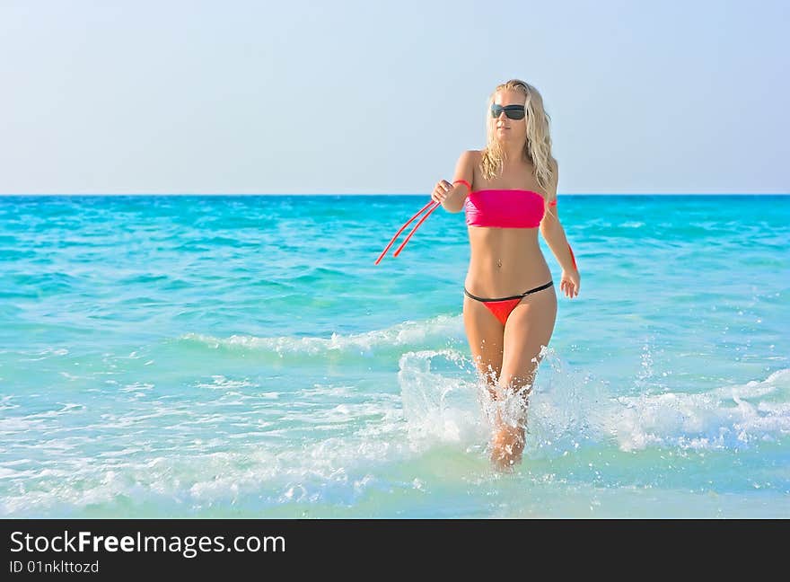 Blonde girl going out of the sea. Blonde girl going out of the sea