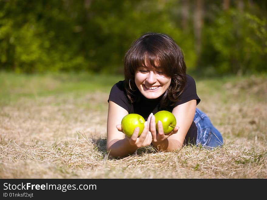 The beautiful young girl with two apples in hands