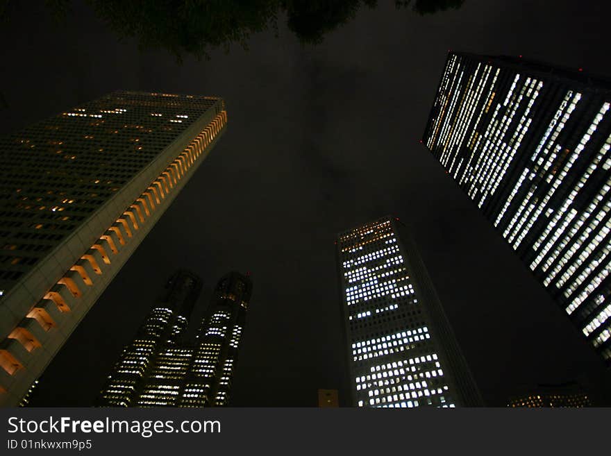 Below view of huge skyscrapers in Tokyo at night. Below view of huge skyscrapers in Tokyo at night