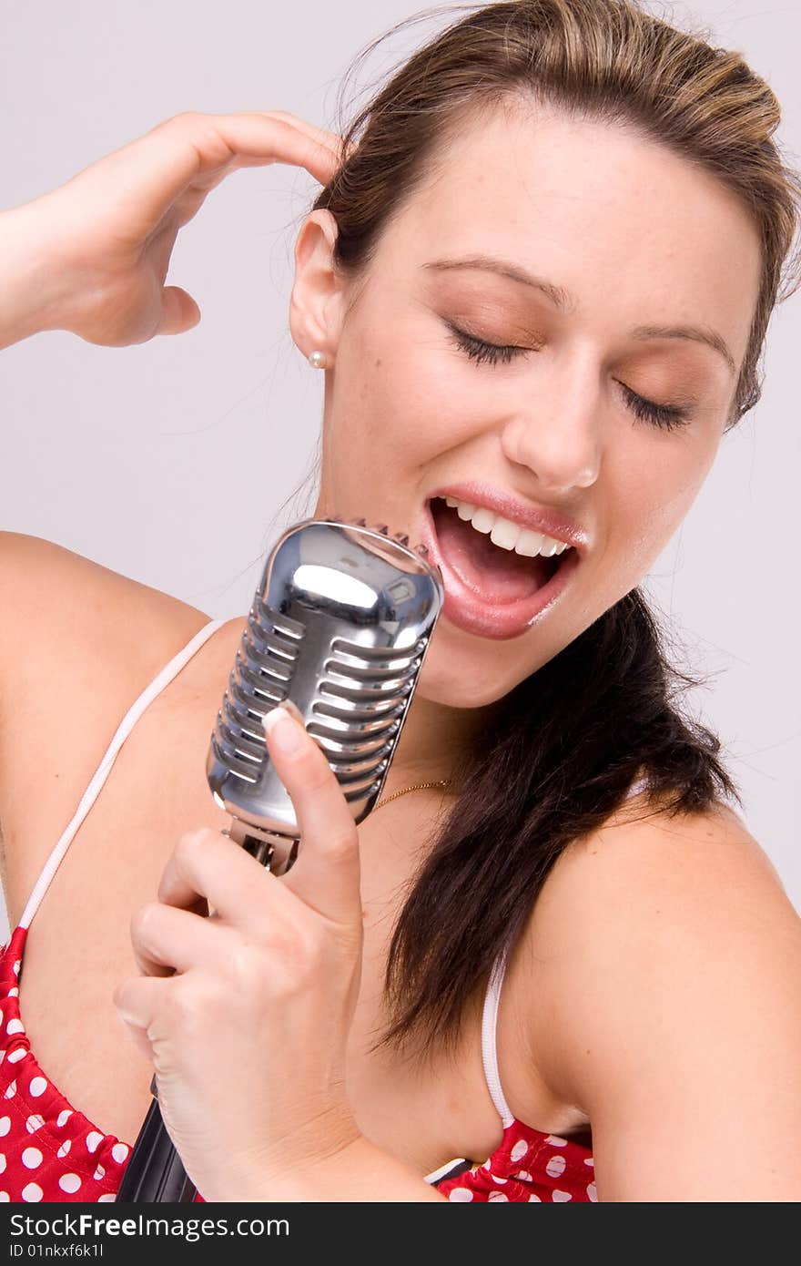 Sexy women in dotty red dress with microphone close-up. Sexy women in dotty red dress with microphone close-up