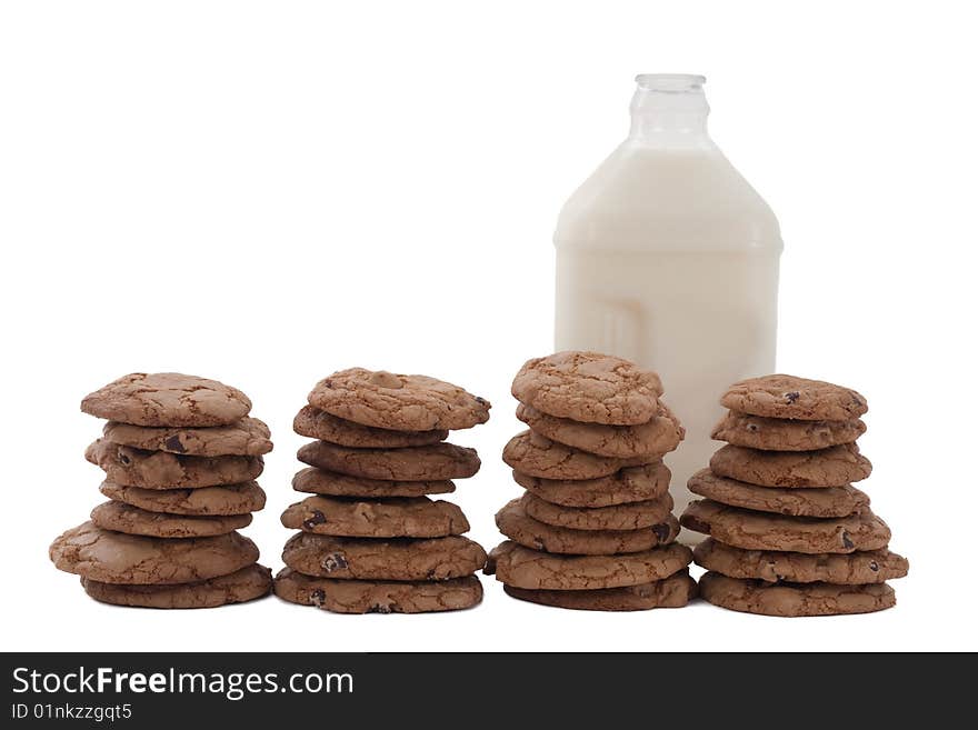 Chocolate chip cookies in four stacks, with a bottle of milk behind. Chocolate chip cookies in four stacks, with a bottle of milk behind