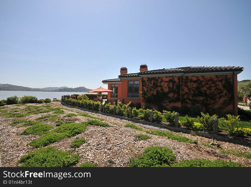 Pink House Surrounded By Plants Overlooking A Bay