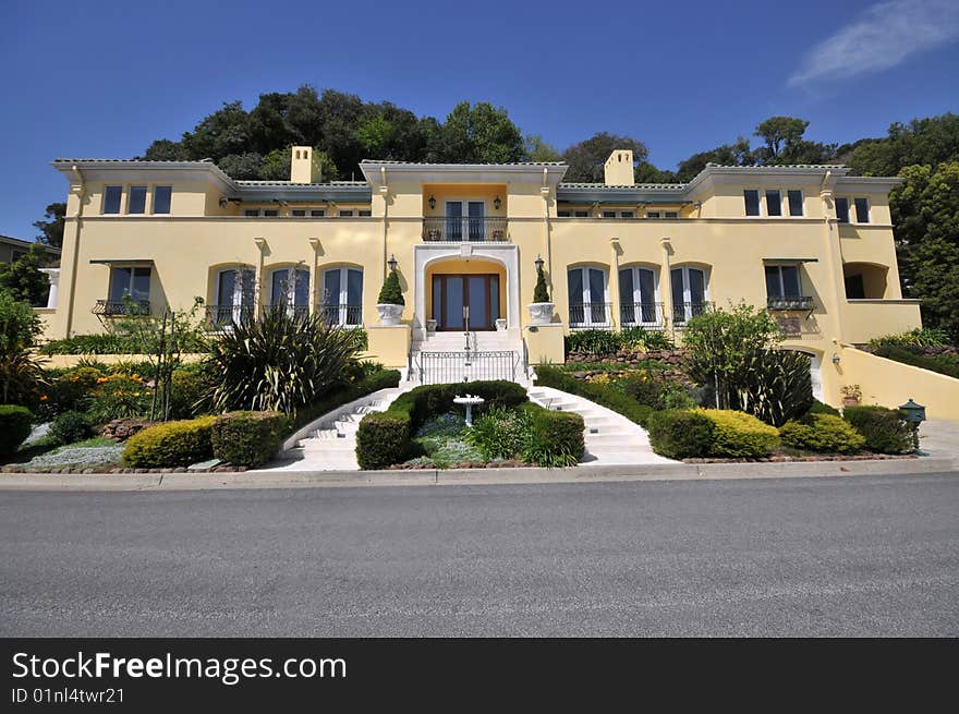 Yellow house with white steps leading to front door. Railings. Shrubs in pots. Yellow house with white steps leading to front door. Railings. Shrubs in pots.