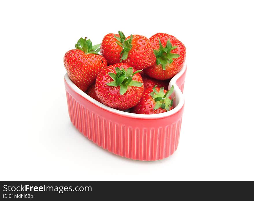 Some delicious strawberries in a heart shaped dish