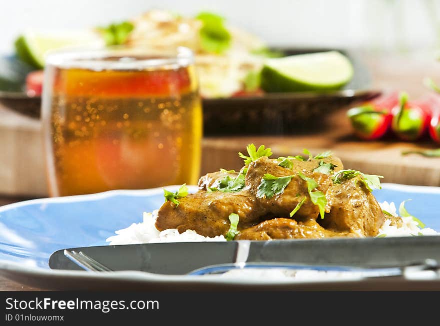 Chicken curry served  with rice and garnished with cilantro leaves