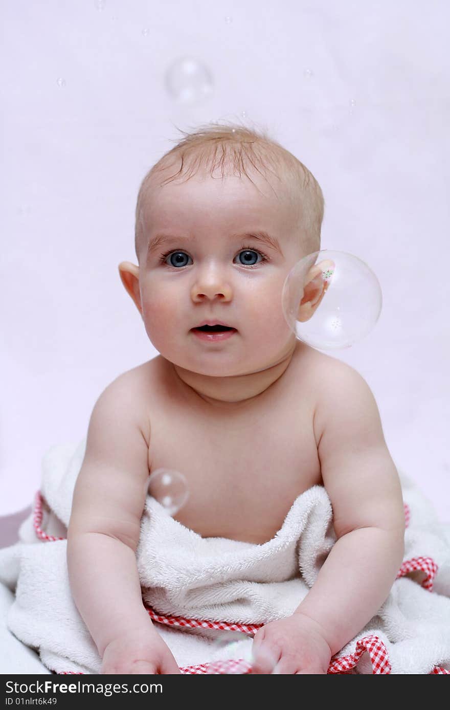 Beautiful baby sitting in a towel with a bubble. Beautiful baby sitting in a towel with a bubble