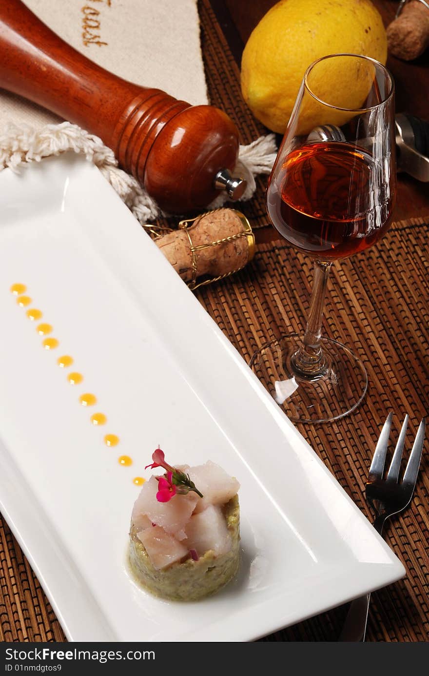 Raw fish on plate decorated with glass of wine. Raw fish on plate decorated with glass of wine