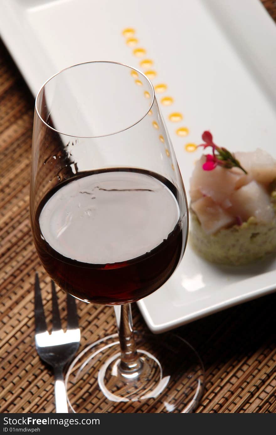 Raw fish on plate decorated with glass of wine. Raw fish on plate decorated with glass of wine