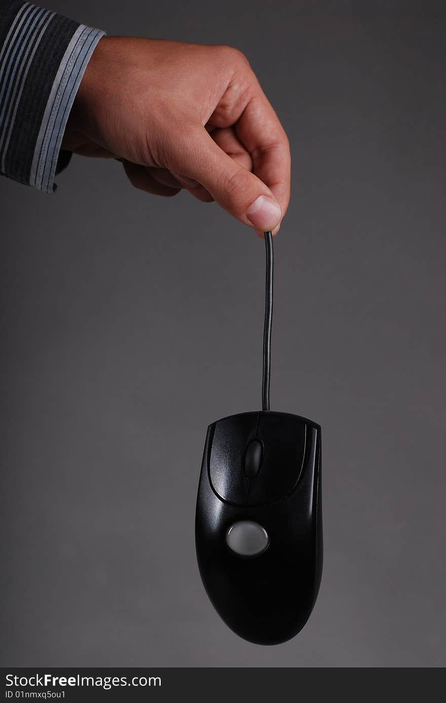 A male hand holding a computer mouse. A male hand holding a computer mouse