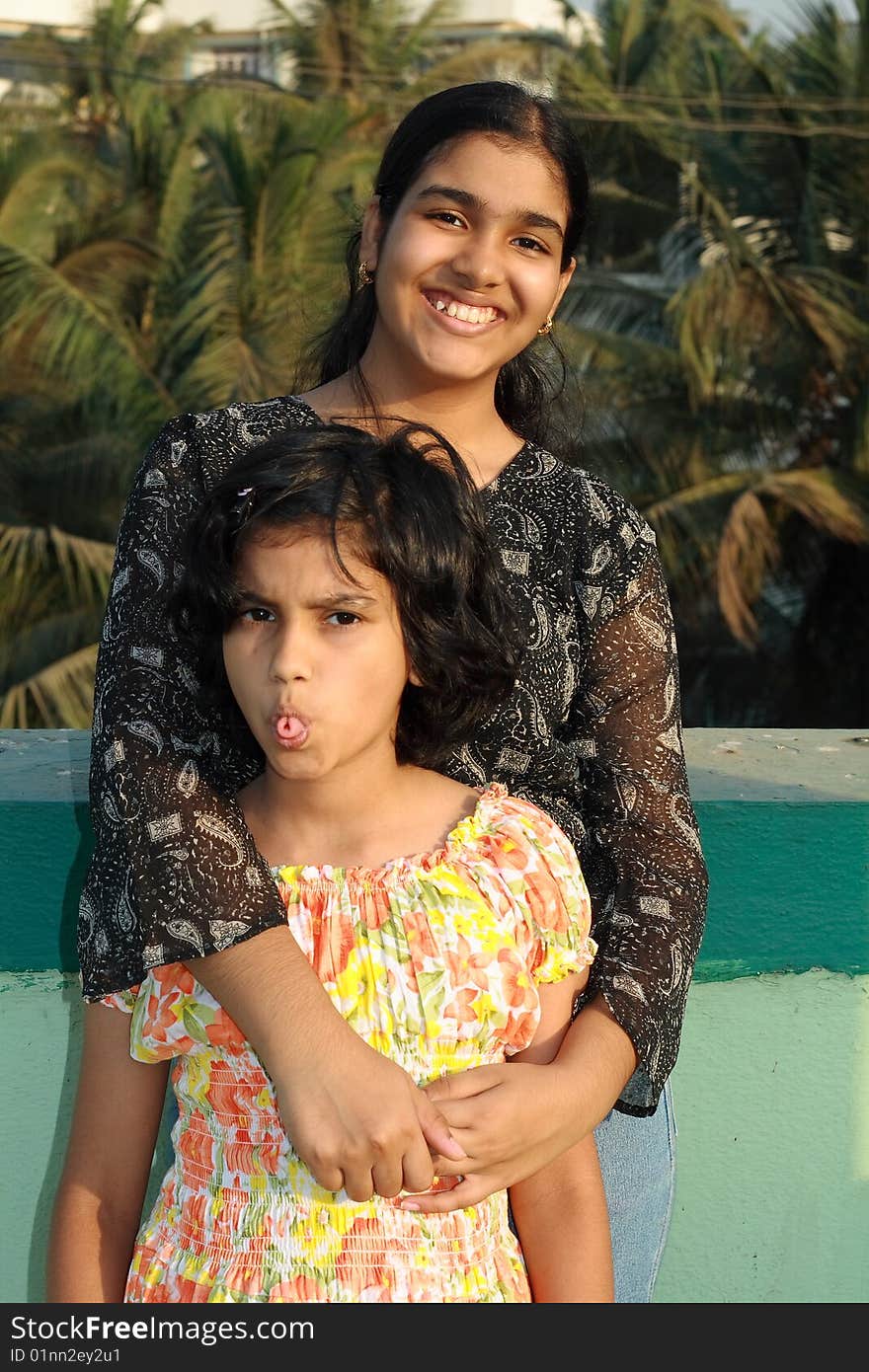 A girl holding her sister in a joyful friendly smile. A girl holding her sister in a joyful friendly smile.