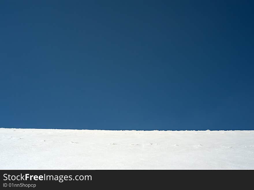 Blue sky horizon with white snow structure. Blue sky horizon with white snow structure