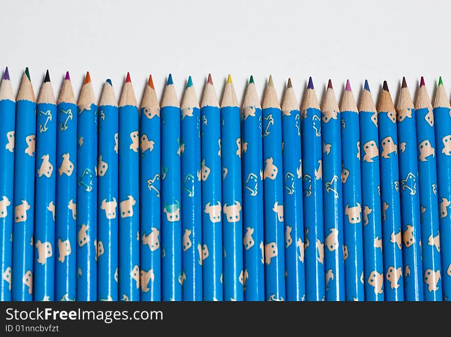 Stack of wooden crayon inside a tube case with one standing out. Stack of wooden crayon inside a tube case with one standing out