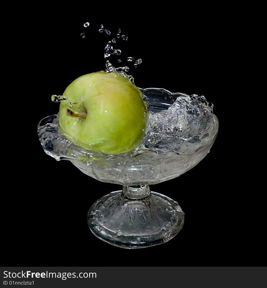 Apple falls into water over black background