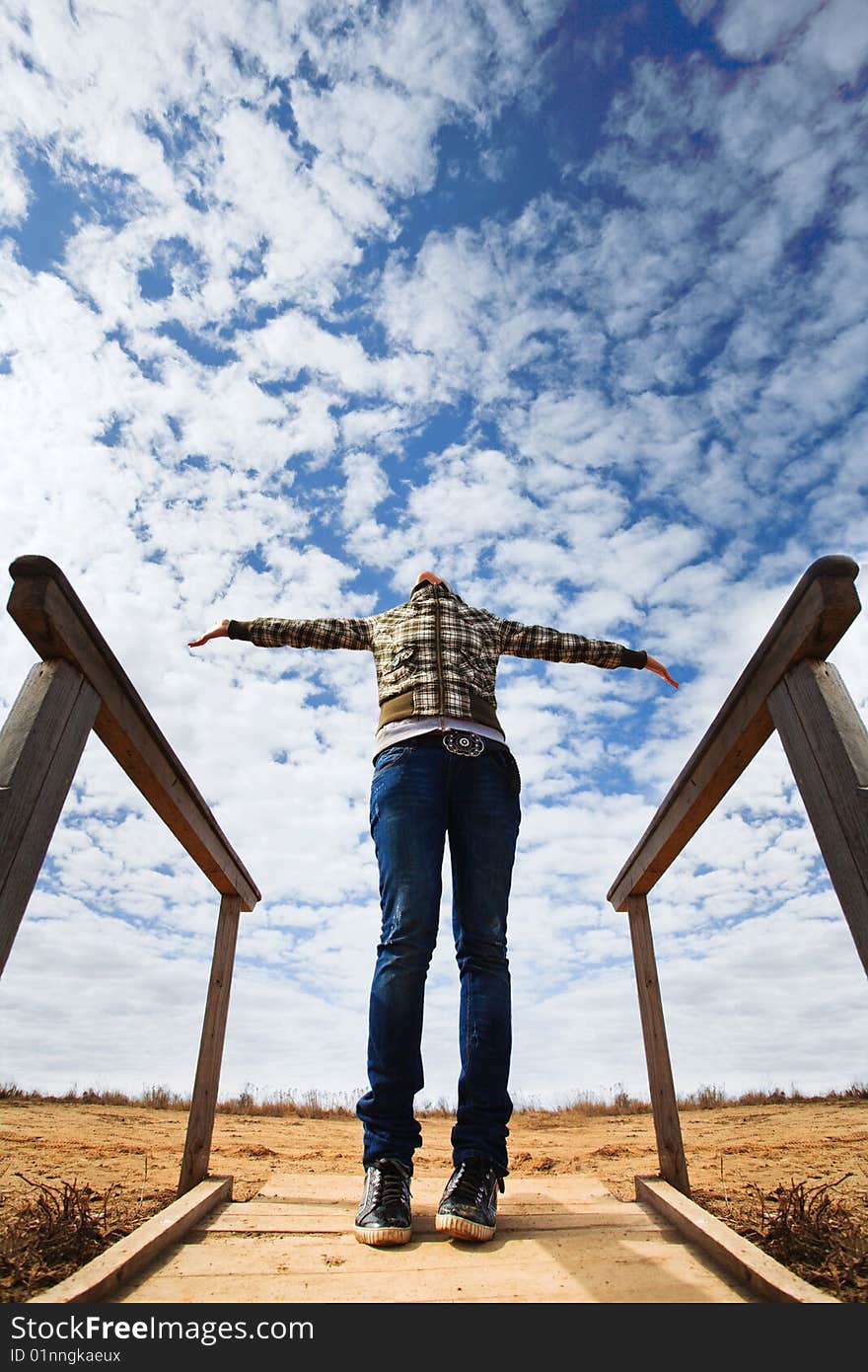 Young girl in jeans against blue sky. Young girl in jeans against blue sky