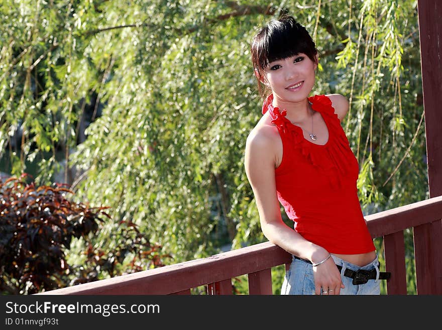 A beautiful Asian girl relaxing outdoors. A beautiful Asian girl relaxing outdoors.