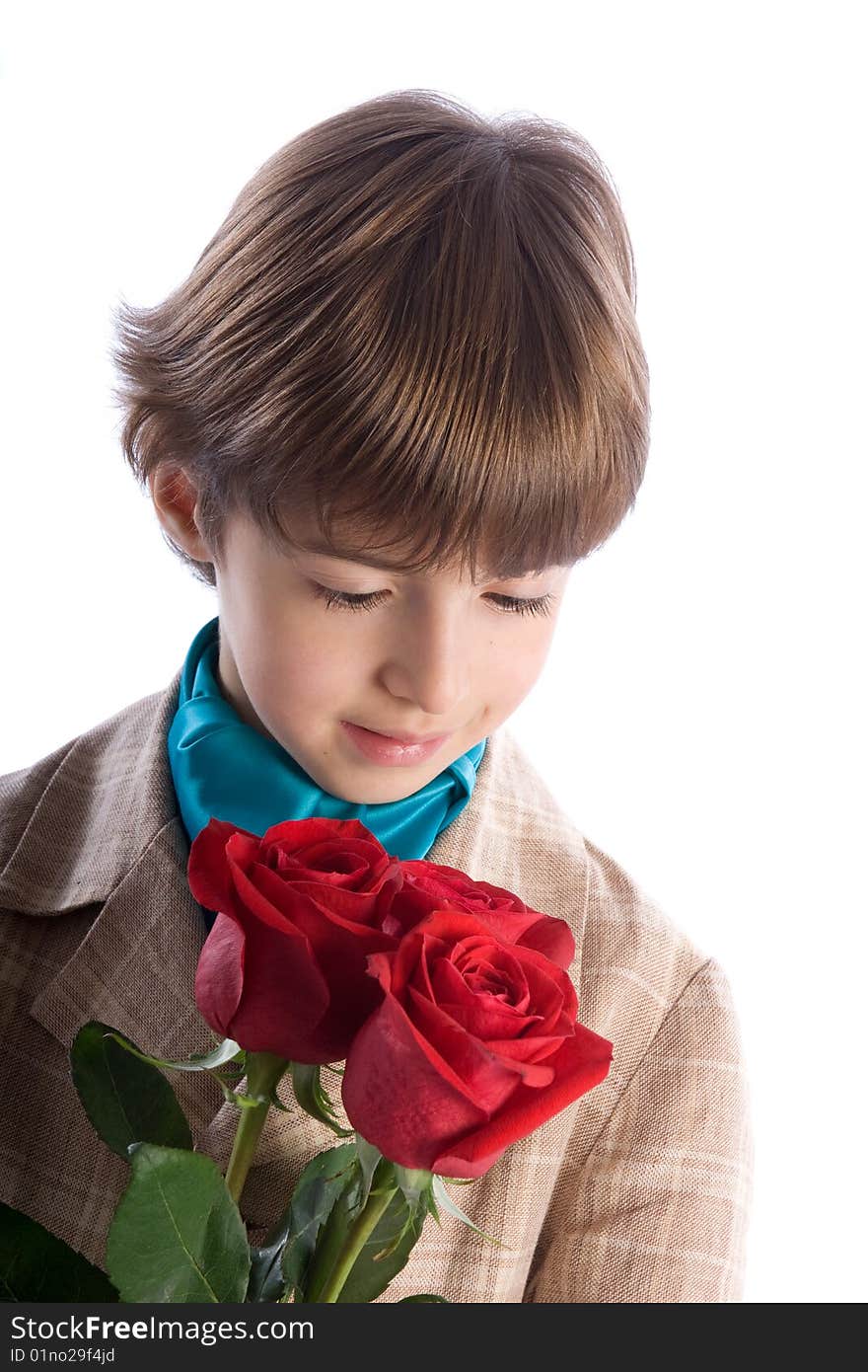 7 years boy inhaling aroma of a bouquet of roses on a white background. 7 years boy inhaling aroma of a bouquet of roses on a white background