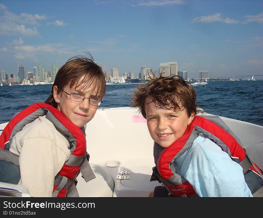 Two boys sitting in a boat with the San Diego Skyline in the background. Two boys sitting in a boat with the San Diego Skyline in the background