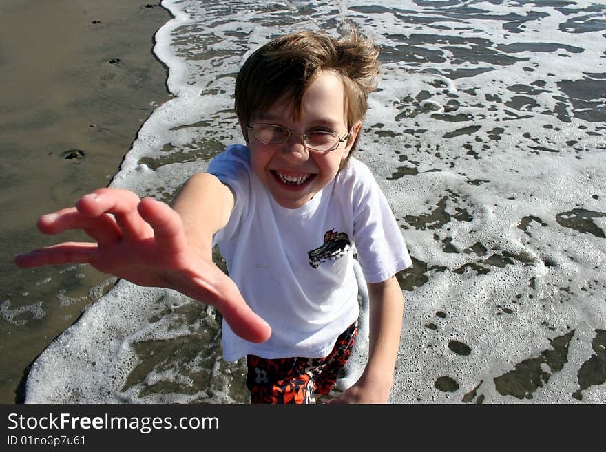 Boy at beach reaching up at you. Boy at beach reaching up at you