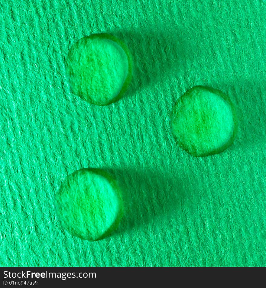 Three green water drops on paper