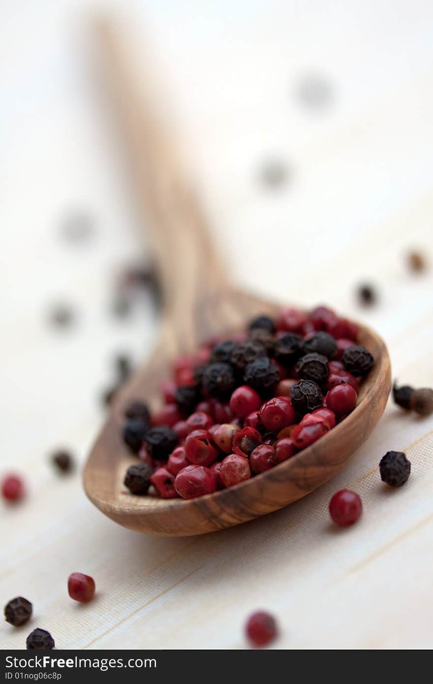 Multicolored Peppercorns in the White Olive-wooden