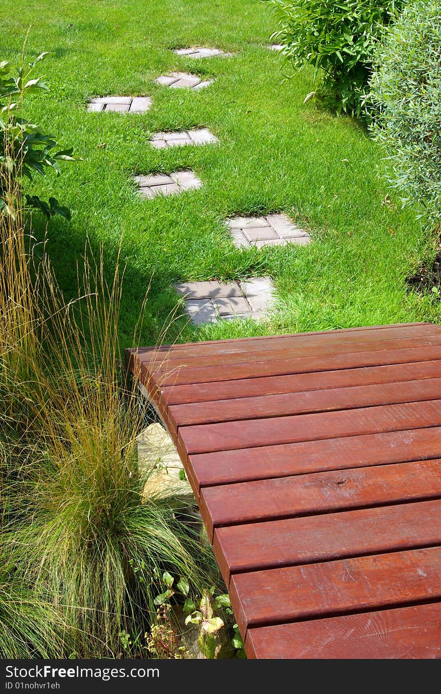 Garden stone path with grass growing up between the stones