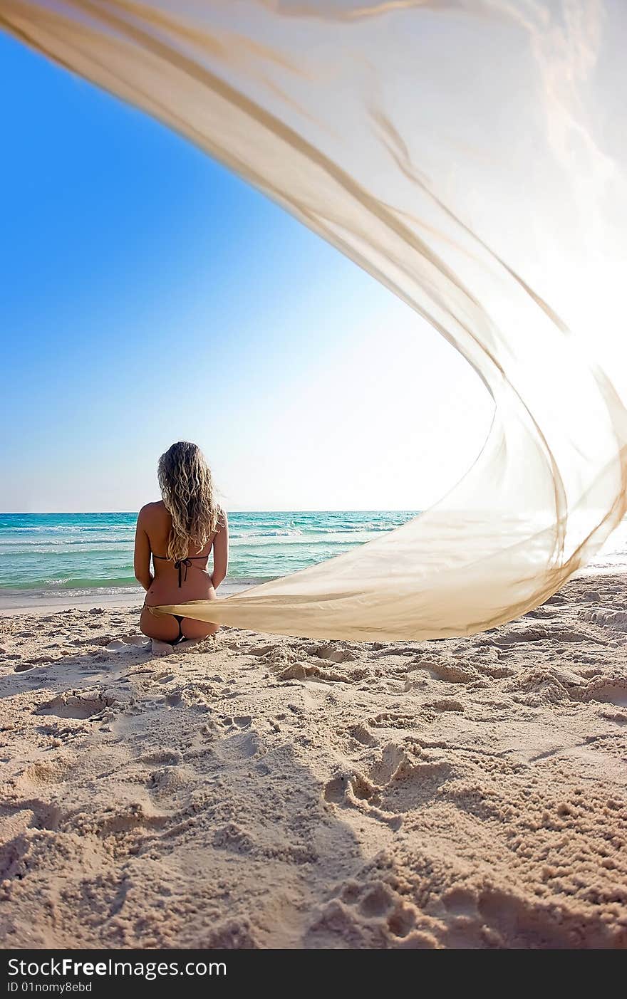 Blonde girl on the beach with shawl