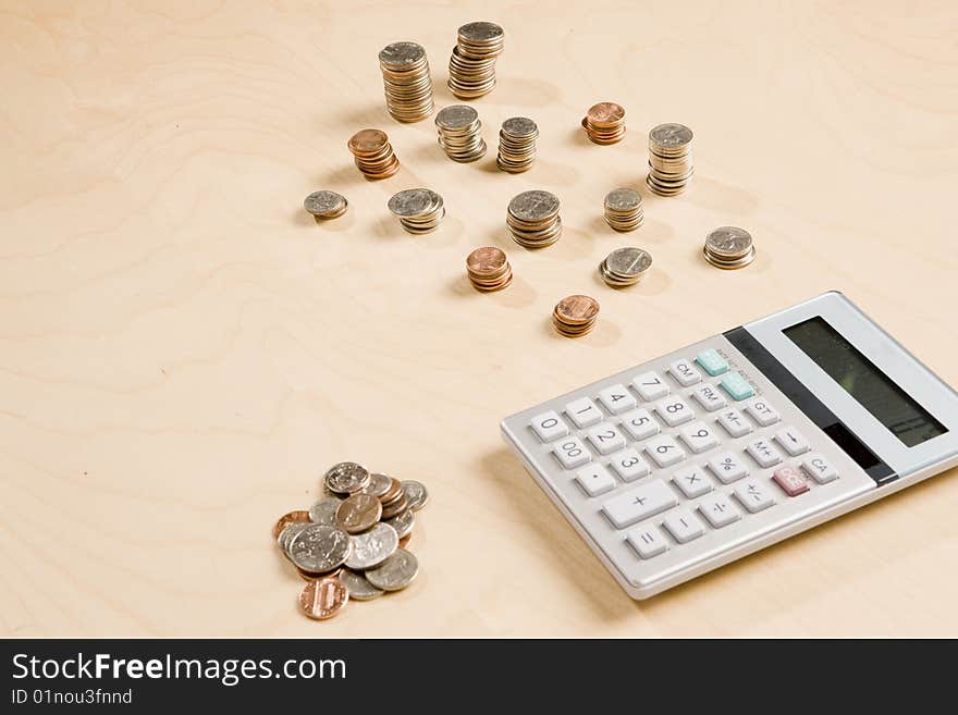 Stacks of change and calculator on desk. Stacks of change and calculator on desk