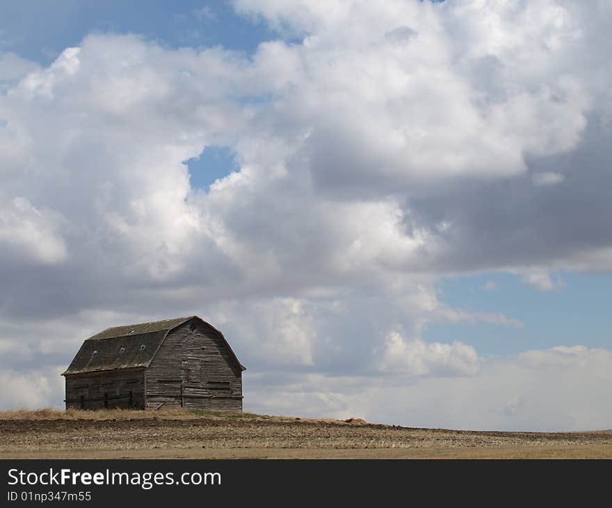 This old barn stands out stark against the sky with the puffy white clouds. This old barn stands out stark against the sky with the puffy white clouds.