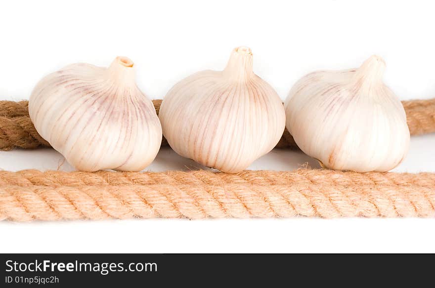 Three Bulbs Of Garlic Near The Rope