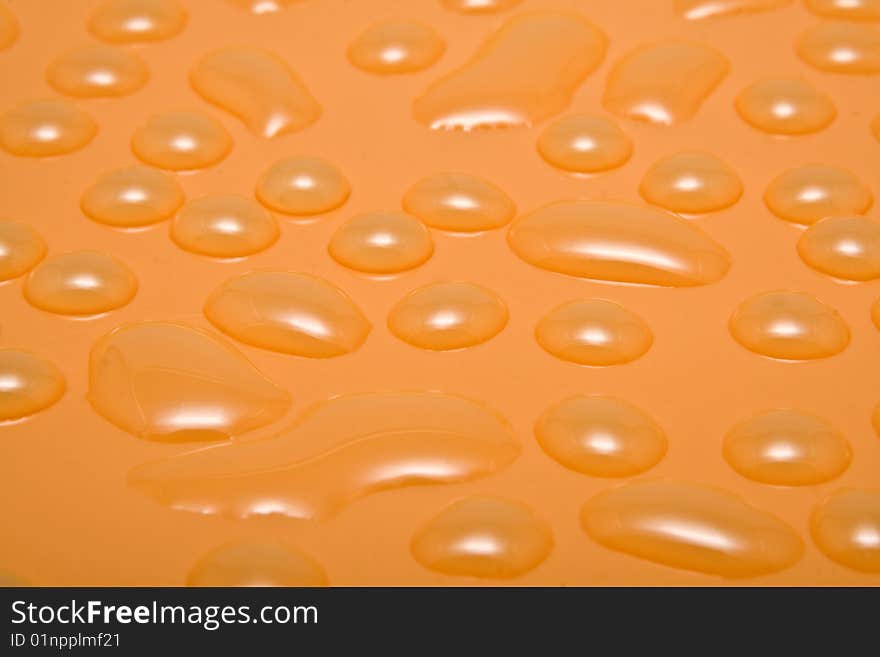 Orange drops of water on a smooth surface