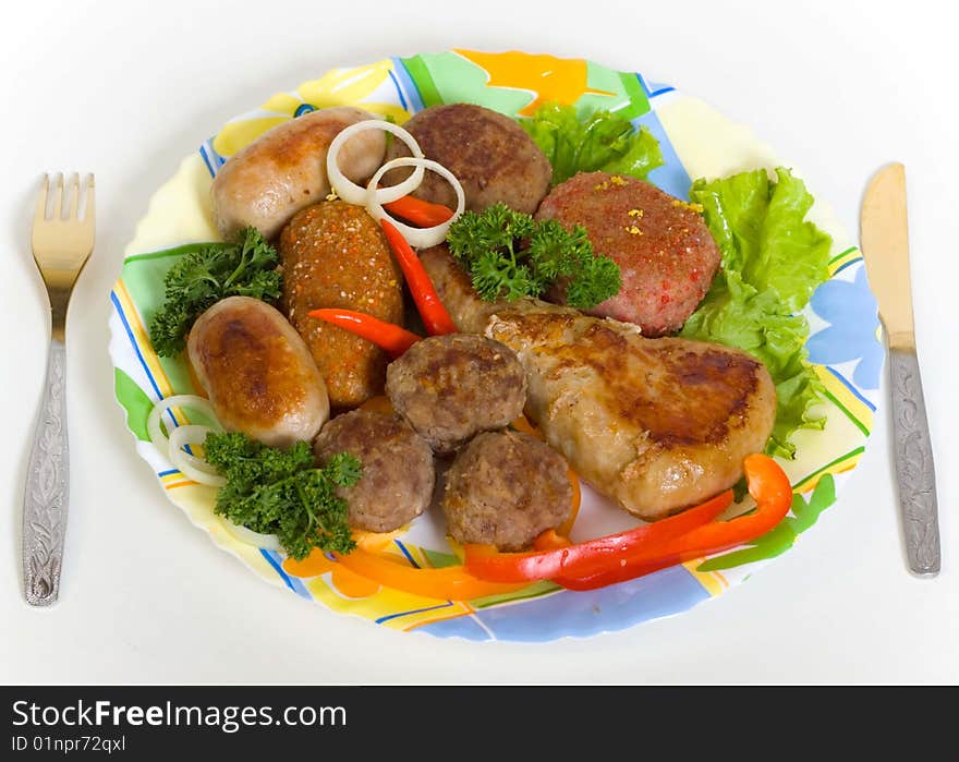 Meat cutlets and small sausages on a plate