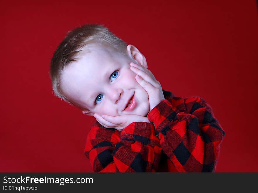 Cute expression on Boy, in Red Flannel, or Red background, blue eyes. Cute expression on Boy, in Red Flannel, or Red background, blue eyes