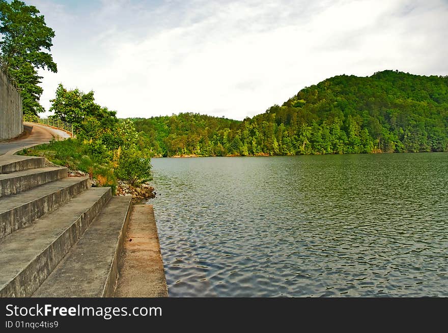 A boat ramp with steps leading to a beautiful lake with spring green trees. Lake Tugalo in GA. A boat ramp with steps leading to a beautiful lake with spring green trees. Lake Tugalo in GA.