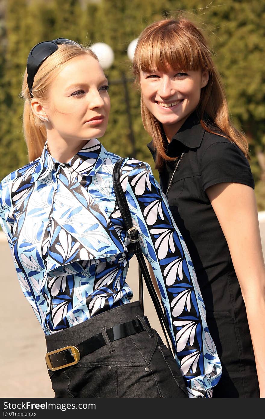 Two friends walking in a city park