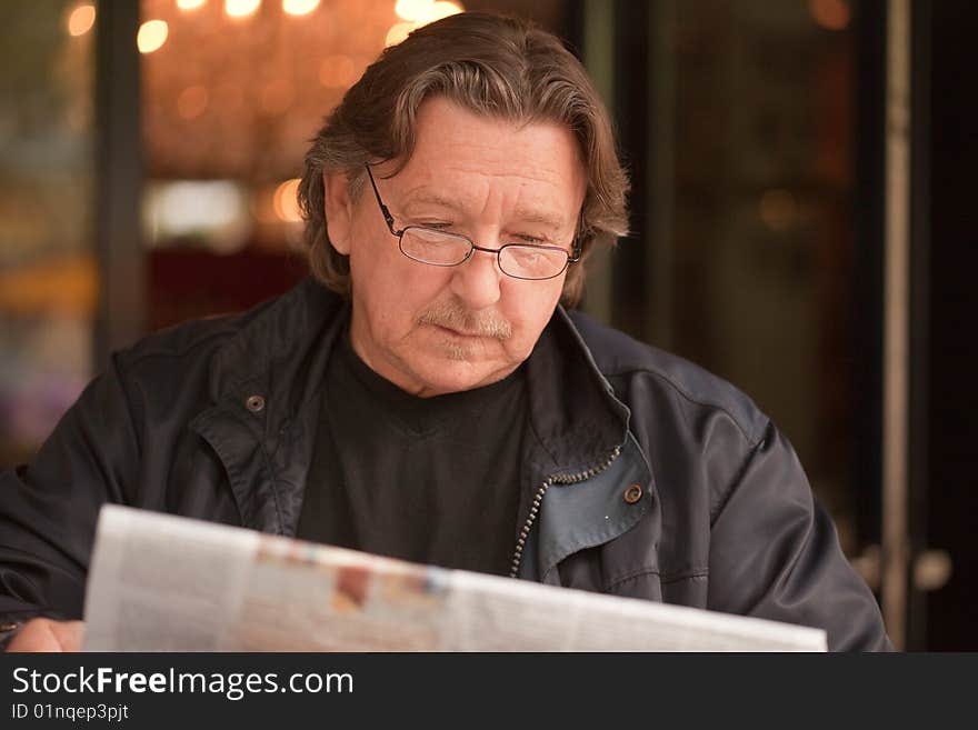 Businessman with glasses Reading A Newspaper in the restaurant. Businessman with glasses Reading A Newspaper in the restaurant