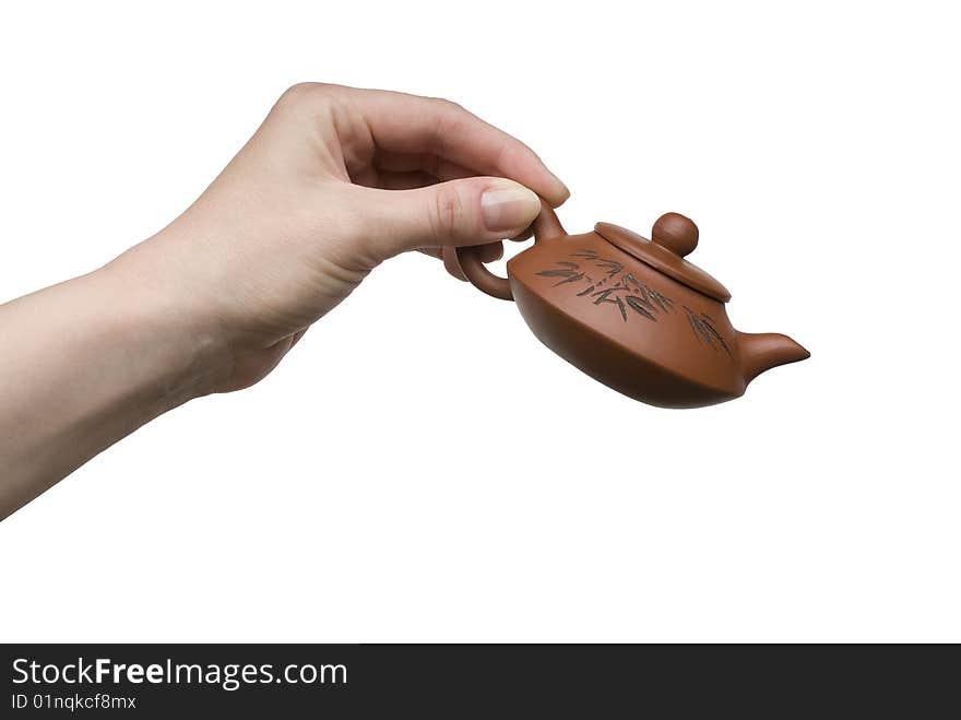 Woman hand with a little clay teapot isolated on white background