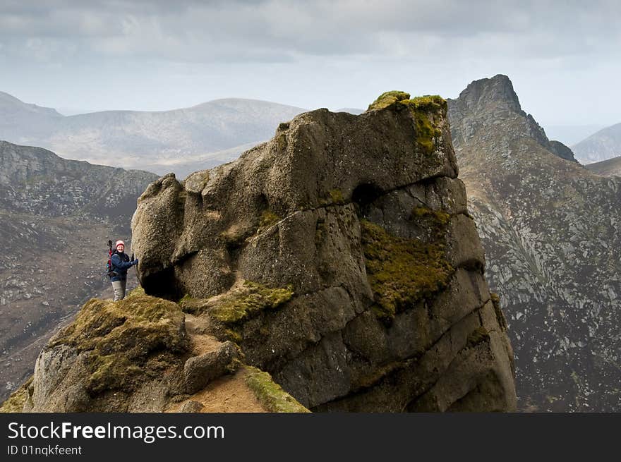 Woman walker with trekking poles on path in the mountains. Woman walker with trekking poles on path in the mountains