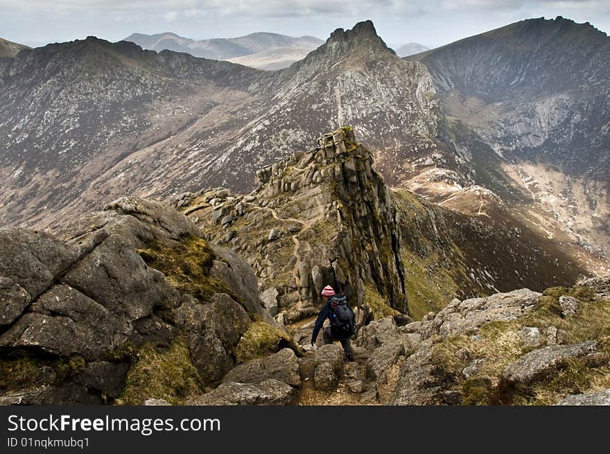 Woman walker with trekking poles on path in the mountains. Woman walker with trekking poles on path in the mountains