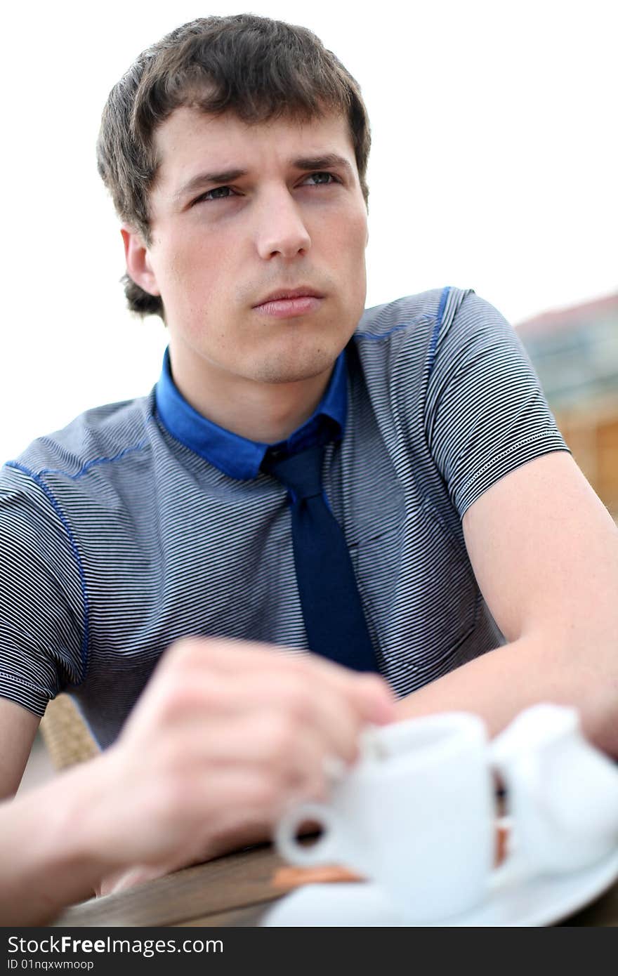 Young man drinks coffee outside. Young man drinks coffee outside.